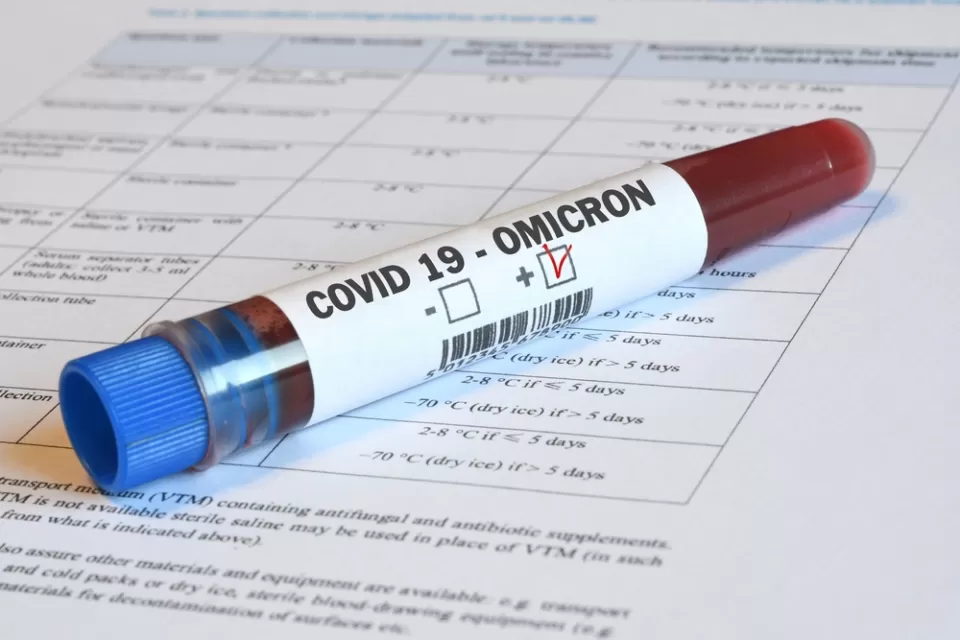 A vial of blood marked "Omicron" sits on top of paperwork indicating relevance to Covid-19.